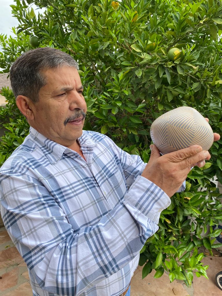 Pilo Mora holding one of his pieces